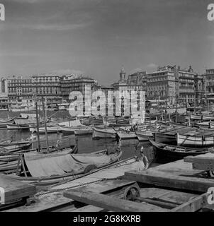 1952, historische Ansicht des alten Hafens von Marseille, Frankreich, mit Holzbooten, die an der Marina festgemacht sind. Marseille, die älteste Stadt Frankreichs, wurde 600 v. Chr. von Griechen aus Phocaea (Türkei) als Handelshafen gegründet. Stockfoto