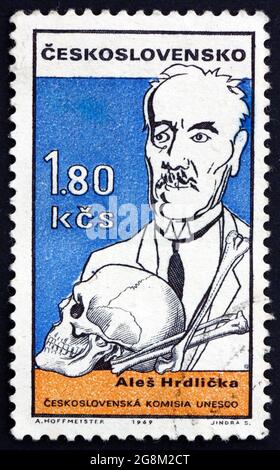 TSCHECHOSLOWAKEI - UM 1969: Eine in der Tschechoslowakei gedruckte Briefmarke zeigt die Karikatur von Ales Hrdlicka (1869-1943), dem in Tschechien geborenen amerikanischen Anthropologen, circ Stockfoto