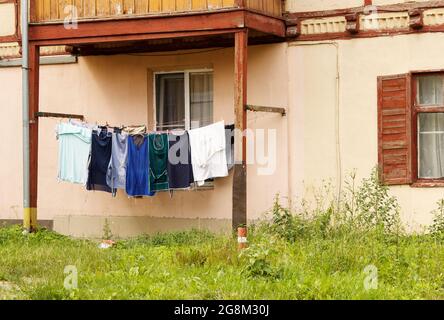 Gewaschene Kleidung wird am Sommertag im Hof an einem Seil getrocknet Stockfoto