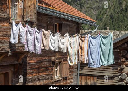 Wäsche an der Leine zwischen alten Holzhäusern Stockfoto