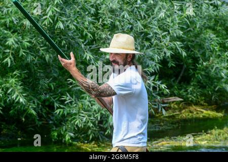 Caterbury, Kent, Juli 21 2021. Ein hart arbeitender Kunde beugt seine Muskeln, während er sein Handwerk entlang des Flusses Stour im Stadtzentrum von Canterbury steuert. Quelle: graham mitchell/Alamy Live News Stockfoto