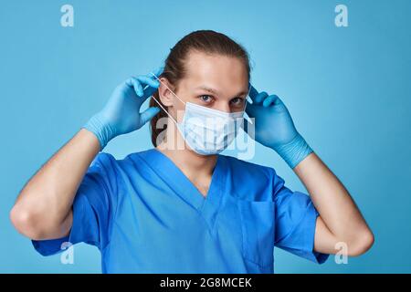 Junger Mann Arzt in Uniform trägt Maske Stockfoto