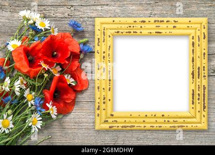 Poppy Blumen Bouquet und Bilderrahmen auf rustikalem Holzhintergrund Stockfoto