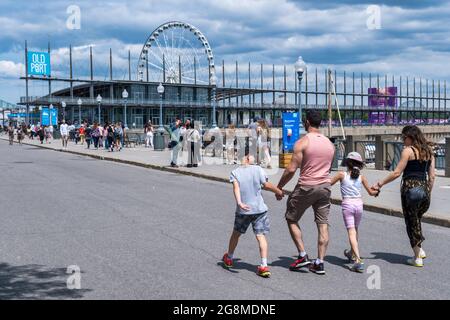 Montreal, CA - 4. Juli 2021: Menschen, die an einem sonnigen Sommertag im Alten Hafen von Montreal spazieren gehen Stockfoto