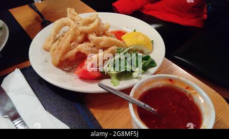 Calamari-Ringe mit Salat und heißer Sauce Stockfoto