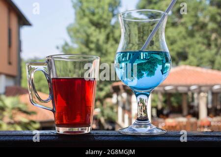 Zwei Tassen, eine mit Hibiskustee und die andere mit einem alkoholischen Cocktail Stockfoto