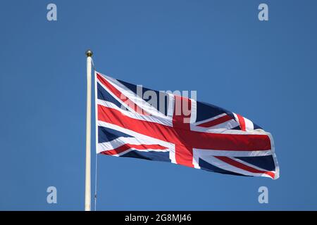 Union Jack Flagge Fliegen in einem Fahnenmast auf Blue Sky Hintergrund Stockfoto