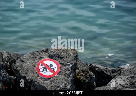 Kein Schwimmschild auf Felsen neben dem Wasser. Warnung. Stockfoto