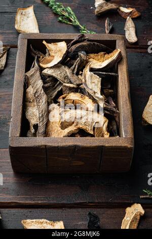 Set aus getrockneten Steinpilzen auf altem dunklen Holztisch Stockfoto