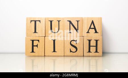 Thunfischphrase, die aus hölzernen Buchstabenwürfeln erstellt wurde. Meeresfrüchte und Essen. Nahaufnahme. Stockfoto