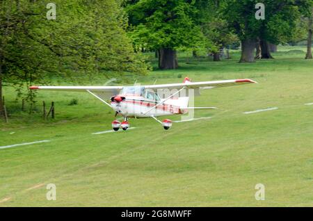 Cessna 172 Skyhawk-Flugzeug, das von einem Grasstreifen in einem bewaldeten, ländlichen Gebiet abfliegt. Henham Park temporäre Grasstreifen für Country-Event Stockfoto