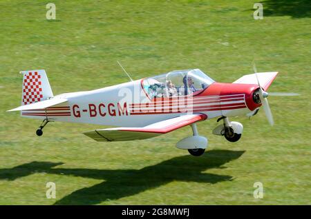 Jodel D120 Paris schönes Flugzeug, das auf einem Grasstreifen in einer bewaldeten, ländlichen Gegend landet. Henham Park temporärer Grasstreifen Stockfoto