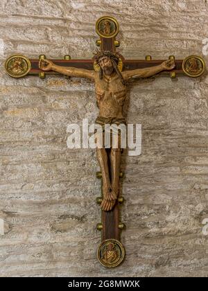 Jesus mit der Dornenkrone, einem alten farbigen Kruzifix aus dem 15. Jahrhundert mit geschältem Gemälde an einer Steinmauer in der Borrie-Kirche, Schweden, Ju Stockfoto