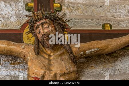 Jesus mit der Dornenkrone, ein altes farbiger Kruzifix aus dem 15. Jahrhundert mit geschältem Gemälde, Borrie Kirche, Schweden, 16. Juli 2021 Stockfoto