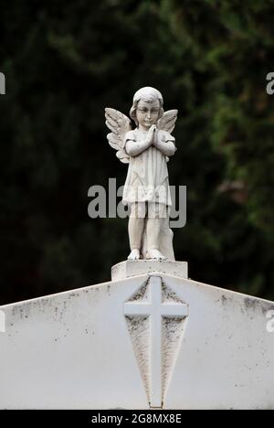 Kleine Statue eines kleinen Engelsmädchen mit den Flügeln am Grabstein auf dem alten Friedhof in Dalmatien, Kroatien, aus der Nähe Stockfoto