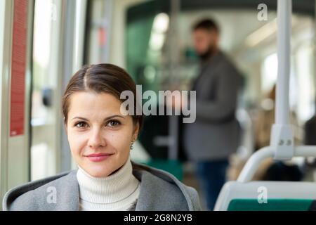 Positive junge Frau im Stadtbus Stockfoto