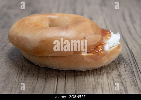 Frischkäse und Gelee Bagel in zwei Hälften geschnitten und bereit zum Frühstück zu essen. Stockfoto