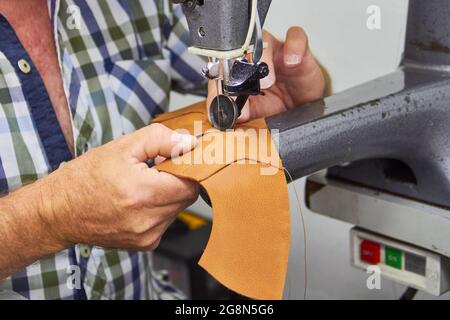 Nähen von Leder für einen Schuh in der Schuhfabrik Stockfoto