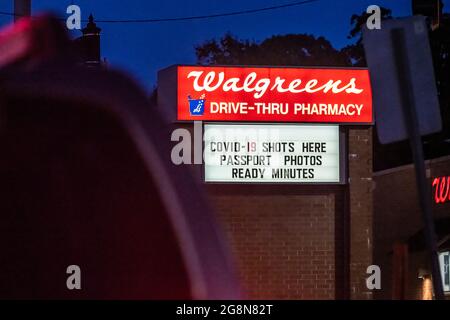 Beleuchtetes Schild für die Walgreens-Apotheke mit COVID-19-Aufnahmen und sofortigen Passfotos in Snellville, Georgia. (USA) Stockfoto