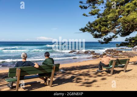 Avalon Beach an einem sonnigen Wintertag in Sydney, während der COVID 19 Lockdown im Großraum Sydney, nehmen sich die Menschen Zeit, um zu sitzen und den Blick auf das Meer zu genießen Stockfoto