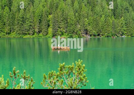 Herrlicher Blick auf den berühmten Prags-See in Italien. Die Menschen rudern die traditionellen Boote aus Holz. Alpensee. Malerischer Bergsee in den Dolomiten. Stockfoto