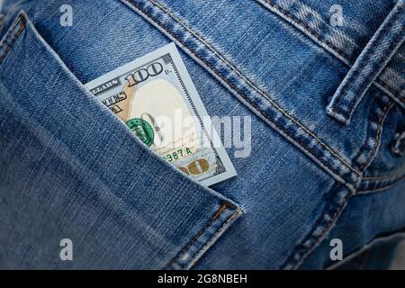 Dollarschein in der Gesäßtasche der Jeans. Hundert Dollar in einer Denim-Tasche. Nahaufnahme Stockfoto