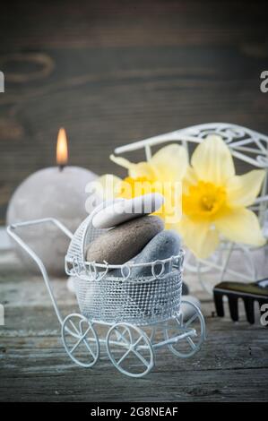 Balancierende Kieselsteine und gelbe Blumen, ZEN Stone Garden auf Holzhintergrund, Spa ruhiges Szenenkonzept Stockfoto