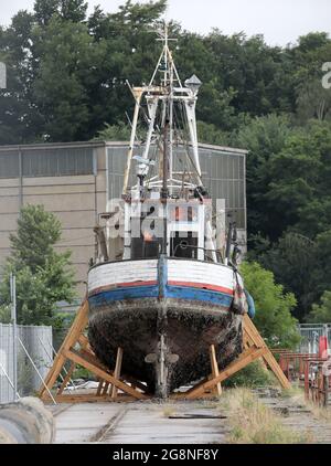 Rostock, Deutschland. Juli 2021. Auf dem Gelände der ehemaligen Neptun-Werft liegen zwei ehemalige Fischkutter an Land. Der ehemalige Fischkutter 'Barth' (l) aus Warnemünde wurde hierher geschleppt und an Land gebracht, weil er kurz vor dem Untergang stand, vor dem ehemaligen Fischkutter 'Wernigerode', der wochenlang auf dem Boden des Stadthafens lag, bevor er gerettet und hierher transportiert wurde. Ob die Fräser verschrottet werden, wird wahrscheinlich noch geklärt, aus wirtschaftlicher Sicht hätten sie wahrscheinlich keine Zukunft mehr. Quelle: Bernd Wüstneck/dpa-Zentralbild/ZB/dpa/Alamy Live News Stockfoto