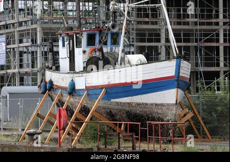 Rostock, Deutschland. Juli 2021. Auf dem Gelände der ehemaligen Neptun-Werft liegen zwei ehemalige Fischkutter an Land. Der ehemalige Fischkutter 'Barth' (l) aus Warnemünde wurde hierher geschleppt und an Land gebracht, weil er kurz vor dem Untergang stand, vor dem ehemaligen Fischkutter 'Wernigerode', der wochenlang auf dem Boden des Stadthafens lag, bevor er gerettet und hierher transportiert wurde. Ob die Fräser verschrottet werden, wird wahrscheinlich noch geklärt, aus wirtschaftlicher Sicht hätten sie wahrscheinlich keine Zukunft mehr. Quelle: Bernd Wüstneck/dpa-Zentralbild/ZB/dpa/Alamy Live News Stockfoto
