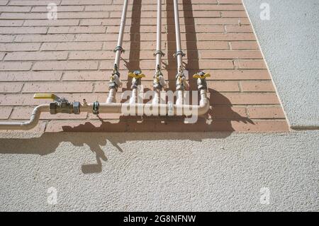 An das Außengebäude angeschlossene Erdgasleitungen für den Hausgebrauch. Selektiver Fokus auf Verbindungen Stockfoto