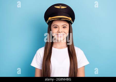 Portrait von attraktiven fröhlichen Mädchen trägt Hut Kopfbedeckung Kapitän isoliert über hellen blauen Hintergrund Stockfoto