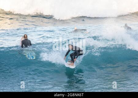 Surfer in einem Neoprenanzug vor der Küste von Avalon Beach in Sydney, NSW, Australien Stockfoto