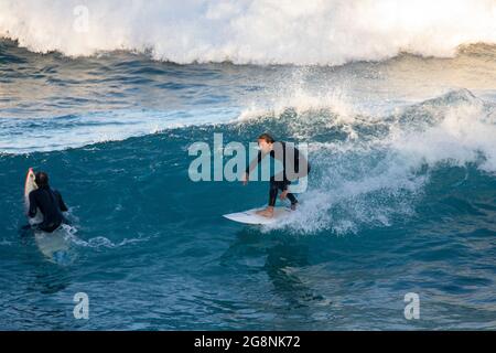 Surfer in einem Neoprenanzug vor der Küste von Avalon Beach in Sydney, NSW, Australien Stockfoto