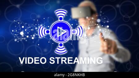 Mann mit vr-Headset, der mit dem Finger ein Videostreaming-Konzept auf einem Touchscreen berührt Stockfoto