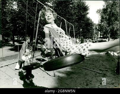 Bei den Außenaufnahmen in Stockholm für eine neue Folge der 6-teiligen Sendereihe 'eine geschiedene Frau' nützte Inge Meysel die Gelegenheit, in einer drehfreien Minute, die gut angelegten schweidischen Kinderspielplätze auszuprobieren. Besonders tat es ihr diese aus einem alten Autoreifen gefertigte Schaukel an. Als sie vom Aufnahmeleiter zur Arbeit gerufen wurde, war ihr einziger Kommentar: 'So ein Ding muss ich unbedingt für meinen Garten in Hamburg haben!' Stockfoto
