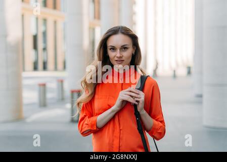 Schöne kaukasische Mädchen mit lockeren Haaren in der Stadt schaut auf die Kamera Stockfoto