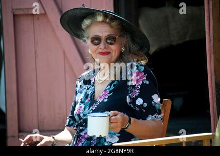 Reife Dame, die bei EINEM Ereignis des Zweiten Weltkriegs aus den 40er Jahren auf der Severn Valley Railway in Shropshire und Worcestershire, England, in Kleidung der 40er Jahre gekleidet war Stockfoto