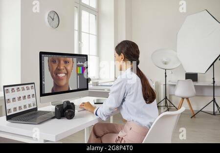 Fotograf arbeitet mit zwei Monitoren, auf denen Bilder des Modells in speziellen Retuschierprogrammen. Stockfoto