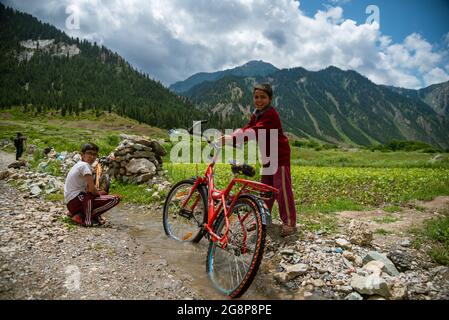 Bandipora, Indien. Juli 2021. Kashmiri-Kinder spielen auf einem Feld in Dawar, Gurez.Gurez liegt entlang der LOC (Line of Control) im nördlichen Teil von Kaschmir. Die Menschen in Gurez sind die Dard-Shins mit ihren Vorfahren, die in Gilgit in Pakistan leben. Die Eigenschaften und die Kleidung des Dard sind ähnlich wie die Kashmiris. Kredit: SOPA Images Limited/Alamy Live Nachrichten Stockfoto