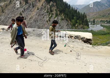 Bandipora, Indien. Juli 2021. Kinder spielen in der Nähe des Grenzzäunens in Tulail, Gurez.Gurez liegt entlang der LOC (Line of Control) im nördlichen Teil von Kaschmir. Die Menschen in Gurez sind die Dard-Shins mit ihren Vorfahren, die in Gilgit in Pakistan leben. Die Eigenschaften und die Kleidung des Dard sind ähnlich wie die Kashmiris. Kredit: SOPA Images Limited/Alamy Live Nachrichten Stockfoto