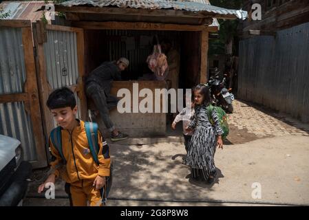 Bandipora, Indien. Juli 2021. Schulkinder gehen an einem Laden in Dawar, Gurez, vorbei.Gurez liegt entlang der LOC (Line of Control) im nördlichen Teil von Kaschmir. Die Menschen in Gurez sind die Dard-Shins mit ihren Vorfahren, die in Gilgit in Pakistan leben. Die Eigenschaften und die Kleidung des Dard sind ähnlich wie die Kashmiris. Kredit: SOPA Images Limited/Alamy Live Nachrichten Stockfoto