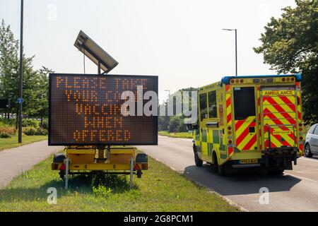 Taplow, Buckinghamshire, Großbritannien. Juli 2021. Ein Notarztwagen besteht eine große Bitte nehmen Sie Ihren Covid-Impfstoff, wenn angeboten LED-Straßenschild auf der A4. Die Zahl der Covid-19-Patienten im Krankenhaus lag gestern in Großbritannien bei 4,658, was im Vergleich zur vergangenen Woche 1,014 ein stieg ist. Nach der Aufhebung der Sperrbeschränkungen in England durch Boris Johnson am Montag gibt es nun Befürchtungen, dass der NHS wieder einmal überfordert sein wird. Quelle: Maureen McLean/Alamy Live News Stockfoto