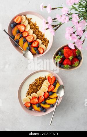 Leckeres gesundes Frühstück, Müsli mit Joghurt und süßem Obst, Banane und Erdbeere, Heidelbeere und Pfirsich Stockfoto