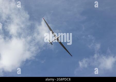 Gleiten Sie gegen den blau bewölkten Himmel. Hochleistungs-Segelflugzeug mit einem Sitz. Stockfoto