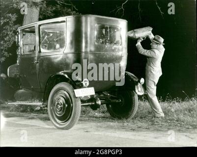 Szenenbild aus dem Film 'Steig ein und stirb': Nach Tetzner (Peter Drescher) sein Opfer auf den Fahrersitz gesetzt hat, gibt er das Auto mit Benzin und steckt es in Brand. Er will damit sein Verbrechen als Unfall tarnen. Then flatters. Stockfoto