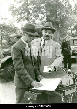 Szenenbild aus dem Film 'Steig ein und stirb': Inspektor Leidinger (Walter Sedlmayr) gibt Anweisungen an einen Kollegen Pfeiffer (Karl Heinz König), das Autorack untersucht. Stockfoto