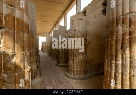 Die aus Stein gemeißelten Säulen der Hypostyle-Halle am Eingang zur Stufenpyramide (Pyramide des Djoser) in Saqqara in Nord-Ägypten. Stockfoto