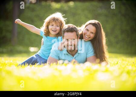 Freundschaft. Vater Mutter und Kind auf grünem Parkgras. Freundliche Familie haben Spaß im Sommer Stockfoto