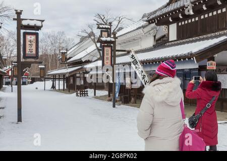 Otaru, Japan-Dezember 22,2017: Asiatische chinesische junge Dame Tourist aus ist in Noboribetsu Datum JIdaimura Historic Village Aufnahme im Winter Stockfoto