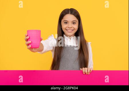 Glücklich Tween Mädchen geben Plastikbecher mit Getränk hält Werbung Brett für Kopie Raum, Getränk Stockfoto